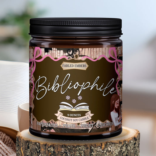 Candle jar labeled 'Bibliophile' on a wooden block with a blurred book in the background