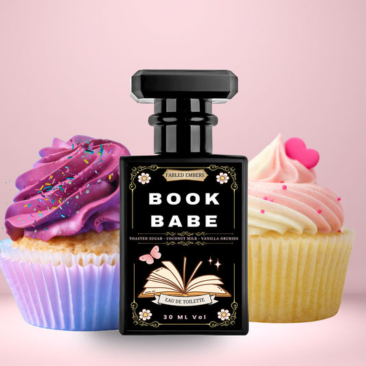 Perfume bottle labeled 'Book Babe' with two cupcakes on a pink background