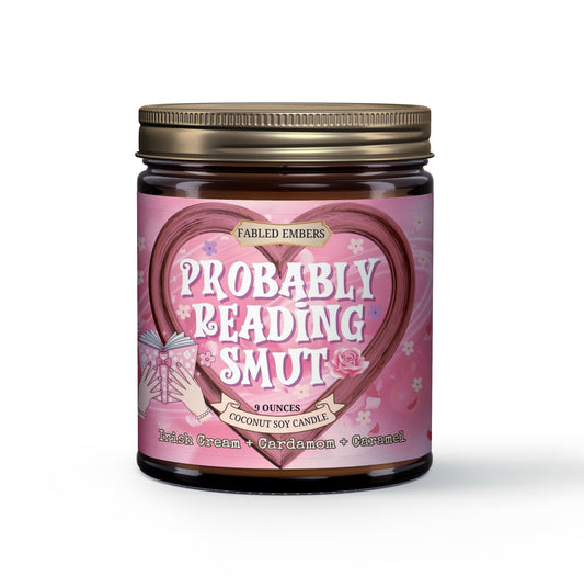 Indulge your passions with our "Probably Reading Smut" coconut soy candle! Its playful label features a heart-shaped design framing the cheeky title, with hands holding an open book. Scented with Irish Cream, Cardamom, and Caramel, it's perfect for your next steamy read.