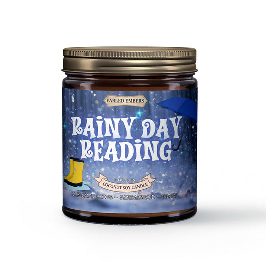 Our "Rainy Day Reading" coconut soy candle perfectly captures the essence of a quiet afternoon. The charming label features sparkling rain, a blue umbrella, and yellow rain boots, inviting you to curl up with a good book. Scented with overcast skies, sandalwood, and grass.