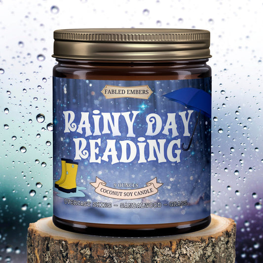Our "Rainy Day Reading" coconut soy candle perfectly captures the essence of a quiet afternoon. The charming label features sparkling rain, a blue umbrella, and yellow rain boots, inviting you to curl up with a good book. Scented with overcast skies, sandalwood, and grass. Bronze lid.