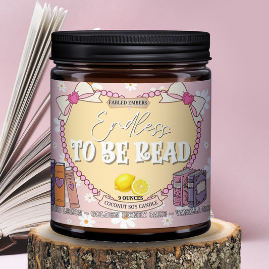 Candle jar labeled 'Endless To Be Read' on a wooden block with an open book in the background.