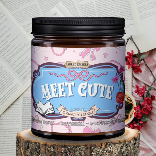 Candle jar labeled 'Meet Cute' on a wooden block with a decorative background