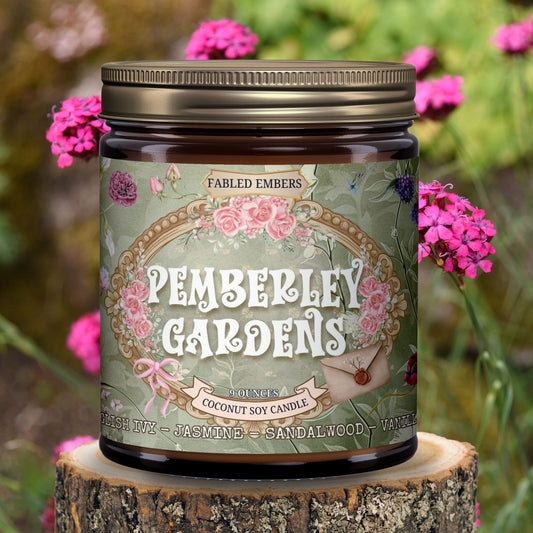 Candle jar labeled 'Pemberley Gardens' on a wooden stump with pink flowers in the background. Jane Austen.