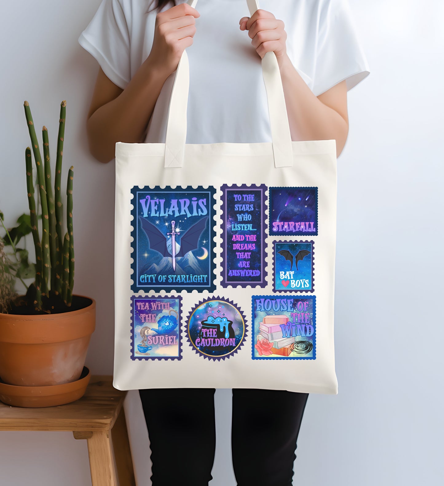 Person holding a tote bag with colorful designs and text against a white background